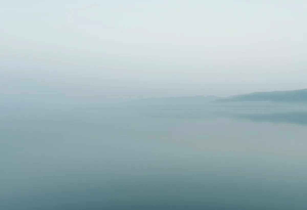 A quiet window seat with a cup of tea and a soft blanket, conveying calm.